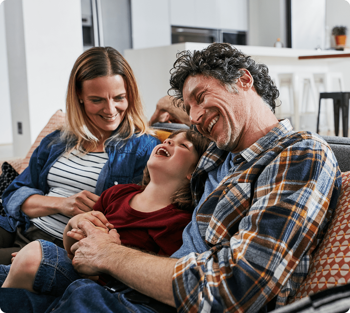 Family laughing together on a couch.